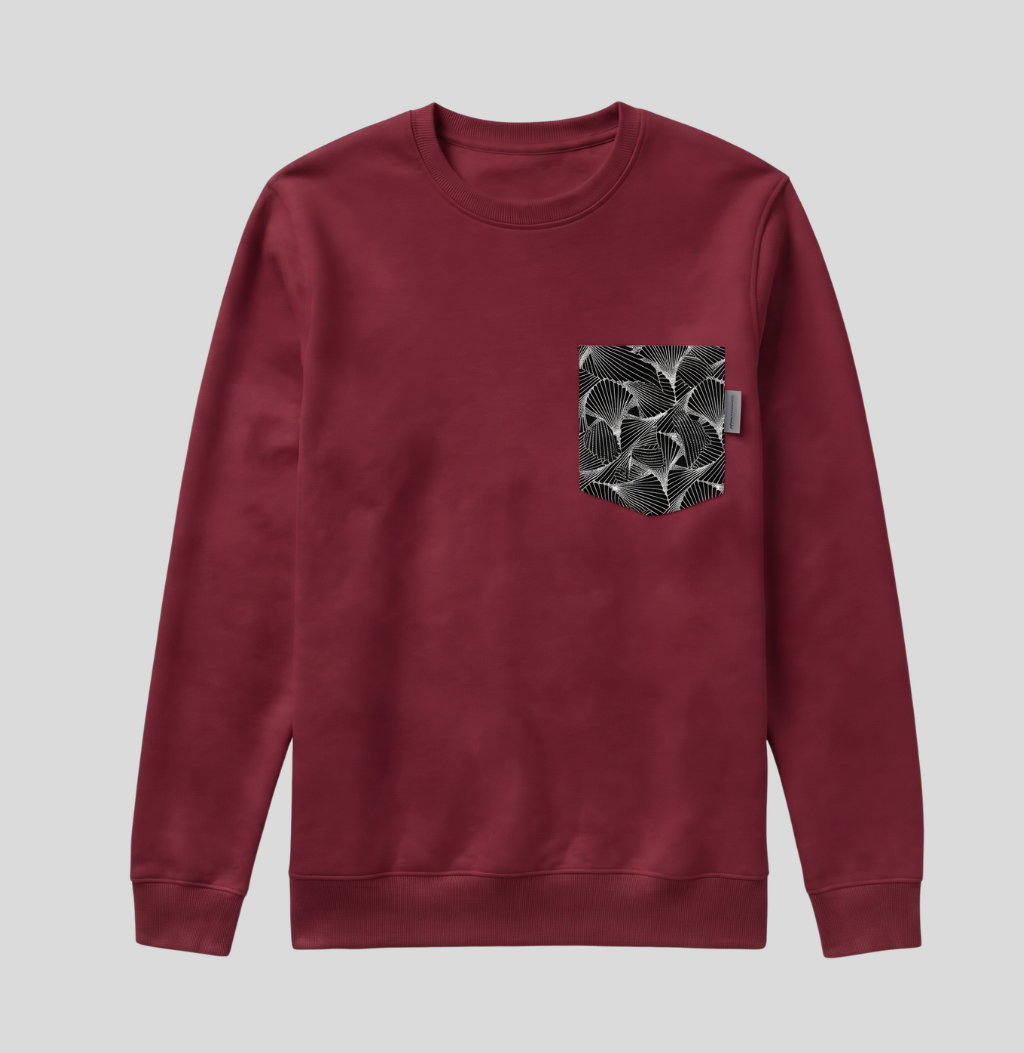 A crewneck sweatshirt in maroon with a black and white patterned pocket on the left chest, displayed against a solid gray background.