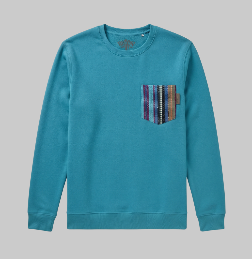 A teal crewneck sweatshirt with a multi-colored striped knit pocket on the left chest, displayed flat against a solid gray background.