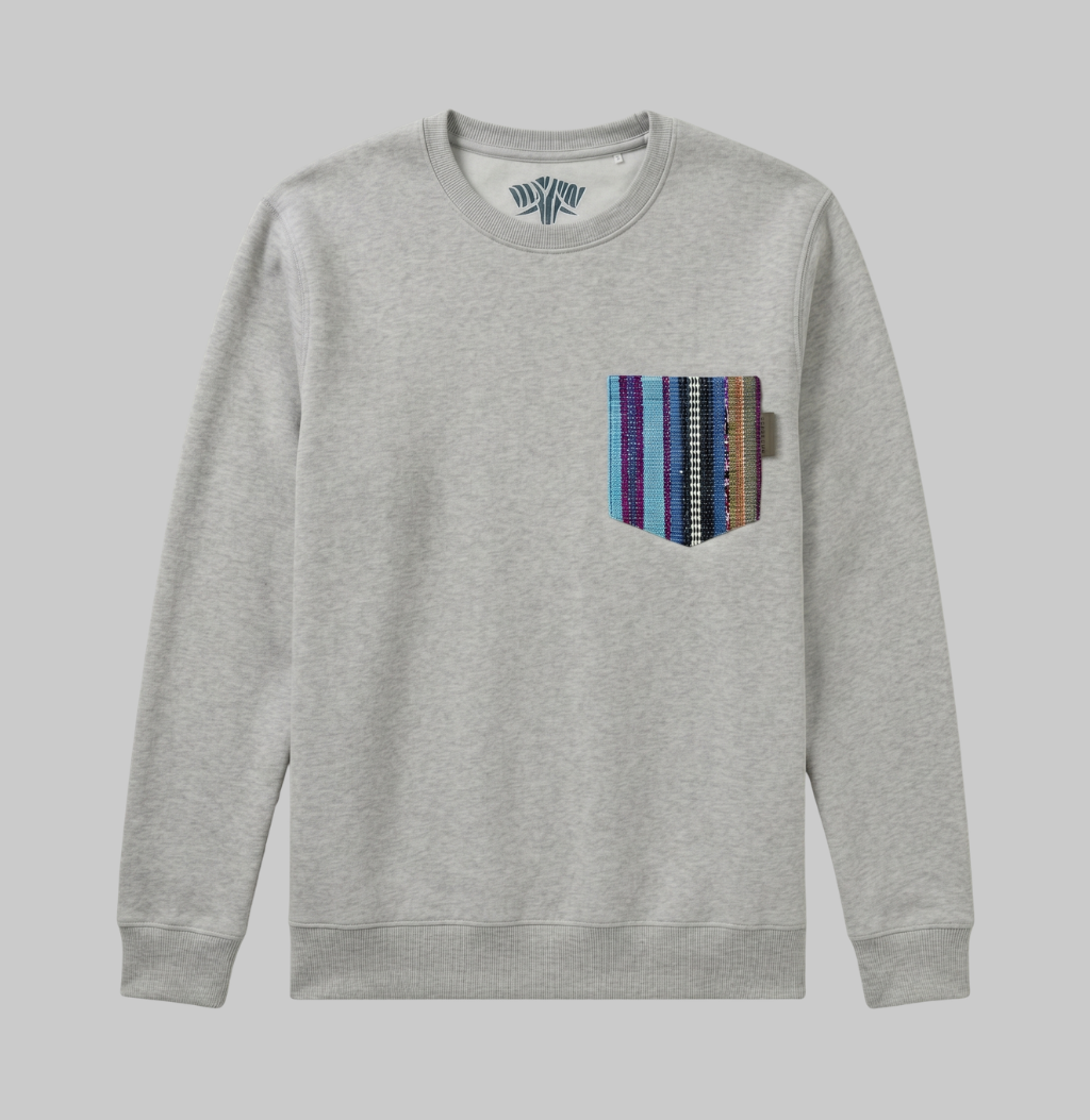 A light heather gray crewneck sweatshirt with a vertical striped patch pocket on the left chest, featuring blue, purple, orange, and brown stripes, shown against a solid gray background.