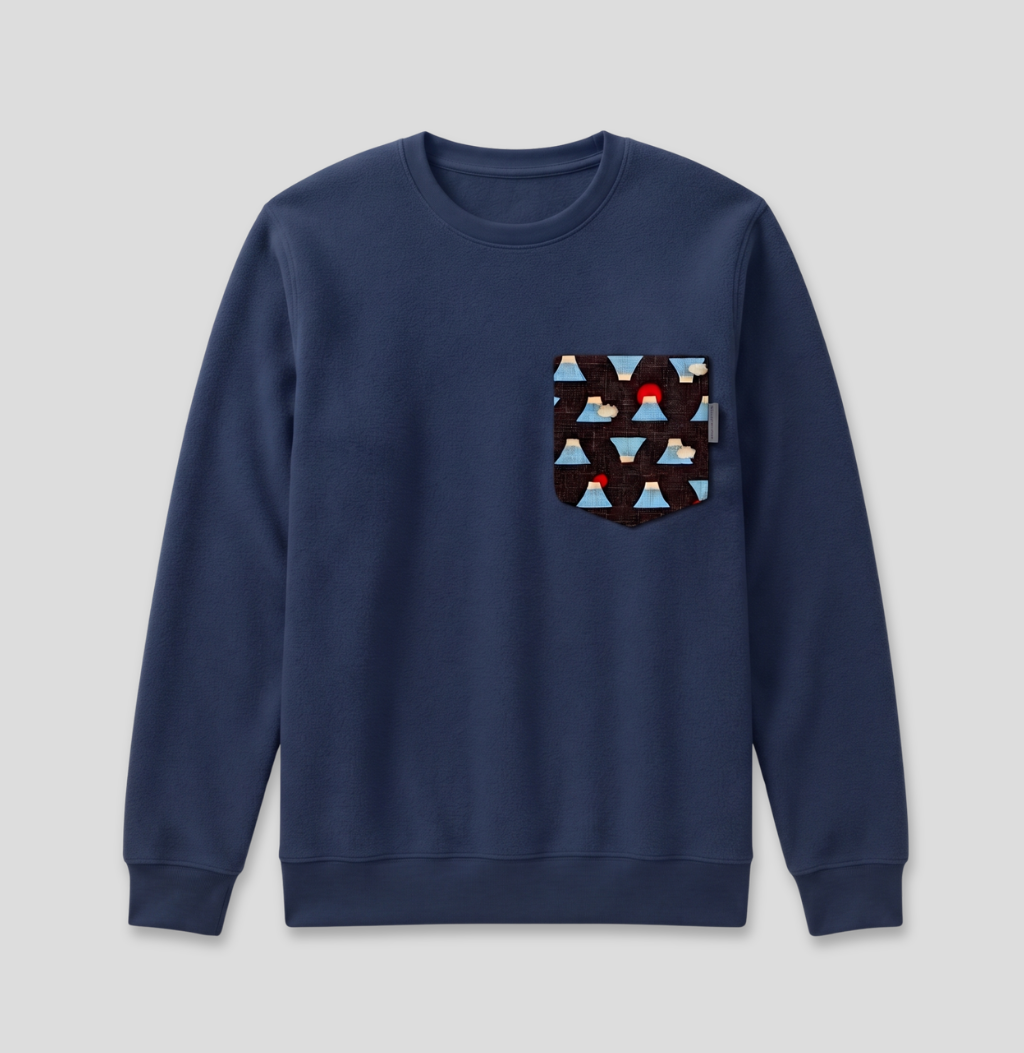 A navy blue crewneck sweatshirt with a patterned chest pocket featuring geometric triangles in light blue, brown, and black with a small red accent.