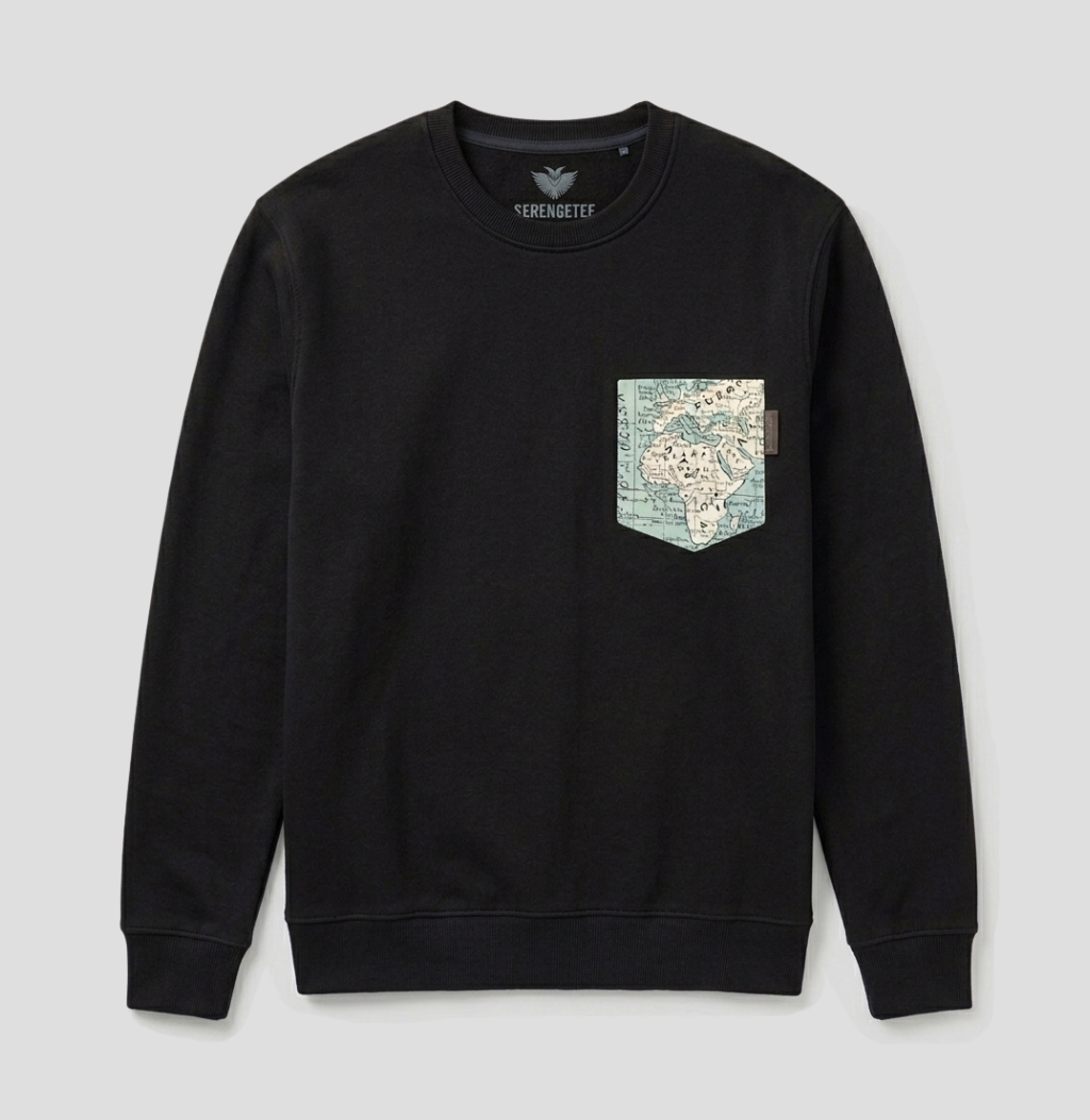 A black crewneck sweatshirt by Veronique featuring a chest pocket with a vintage-style map print in muted blue, beige, and green tones, displayed against a light gray background.