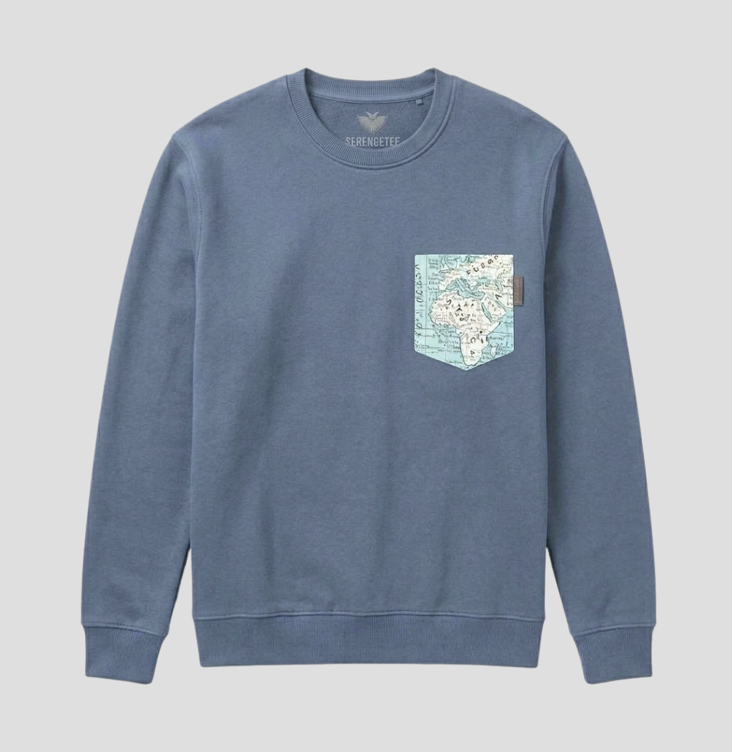 A dusty blue crewneck sweatshirt with a graphic map print on the left chest pocket, shown against a neutral light gray background.