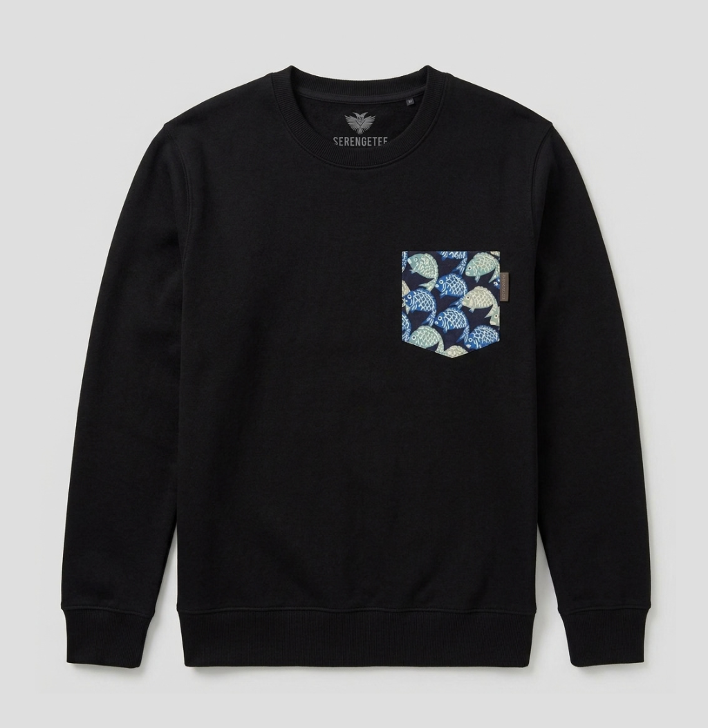 A black crewneck sweatshirt by Serengeti featuring a patterned chest pocket with blue, green, and beige ginkgo leaves on a dark background, displayed against a light gray studio backdrop.