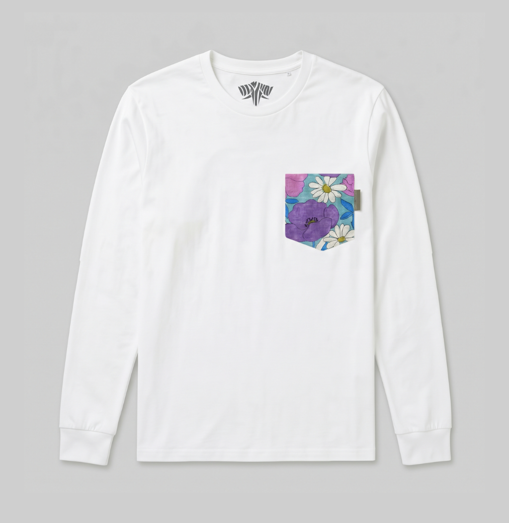 A white long-sleeve crewneck shirt with a colorful floral chest pocket featuring purple flowers and white daisies, displayed on a neutral gray background.