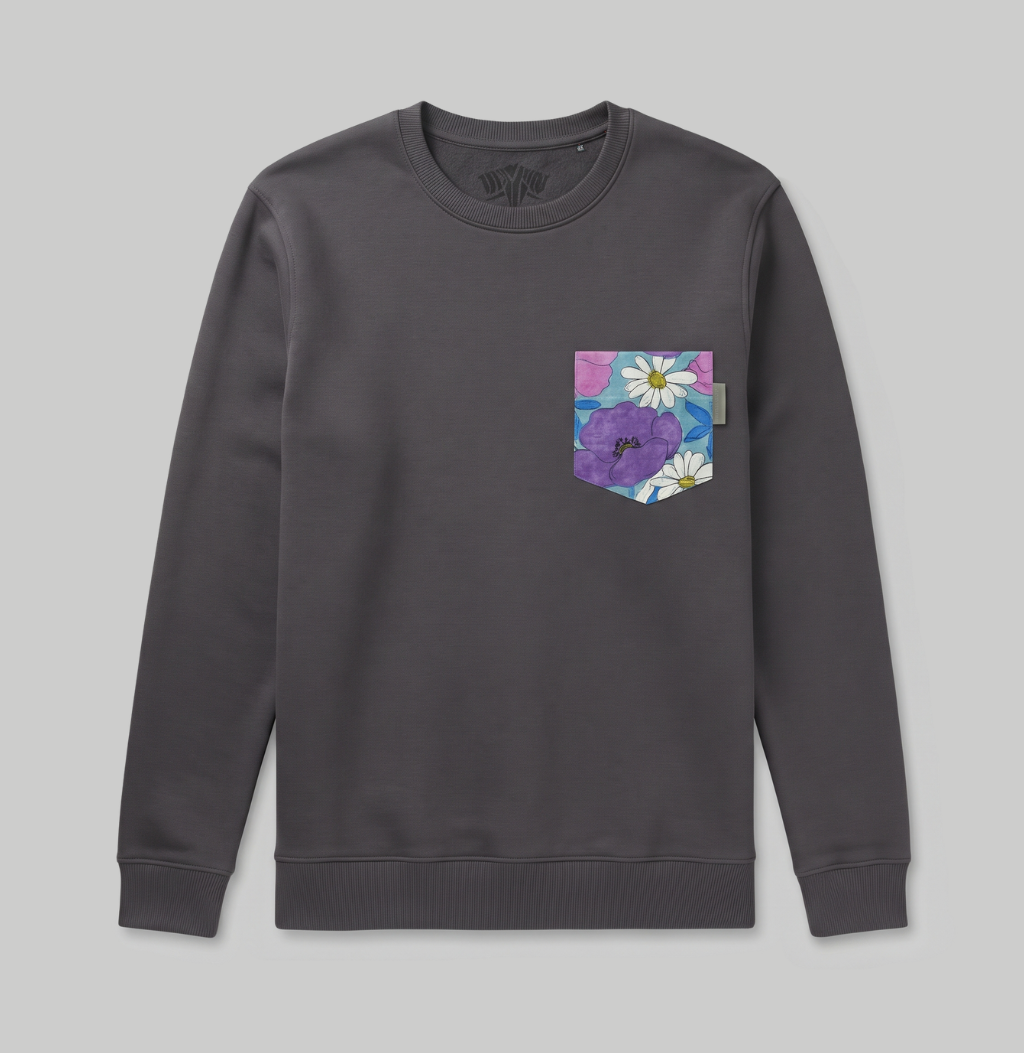 A dark gray crewneck sweatshirt with a colorful floral chest pocket featuring purple flowers and white daisies on a light gray background.
