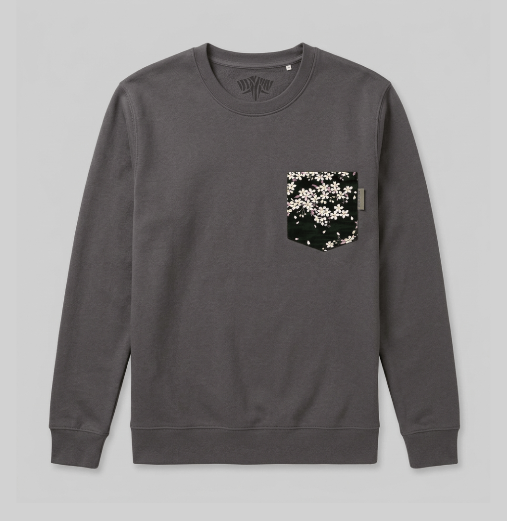 A dark gray crewneck sweatshirt with a chest pocket featuring a black background and a white cherry blossom pattern, displayed flat against a light gray background.