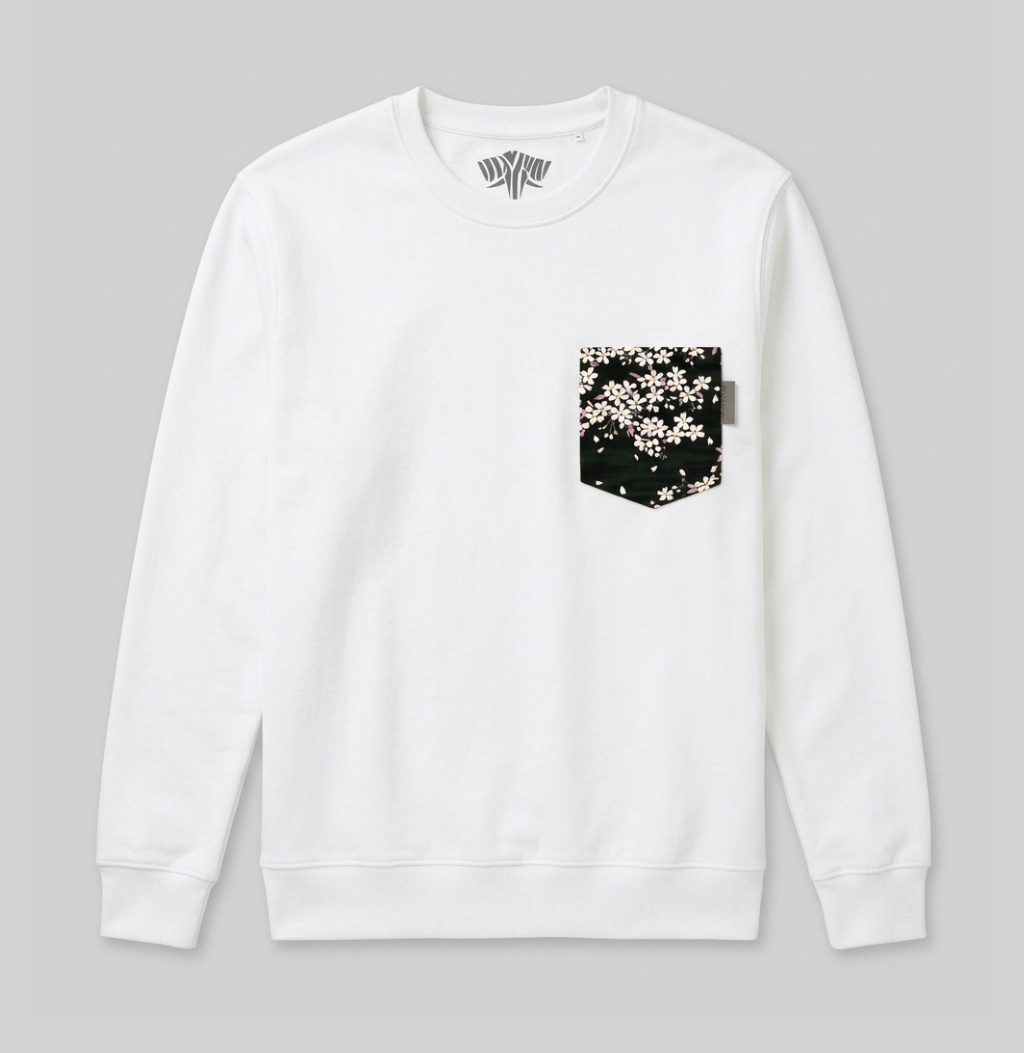 A white crewneck sweatshirt with a black chest pocket featuring a white cherry blossom pattern, displayed flat against a neutral gray background.