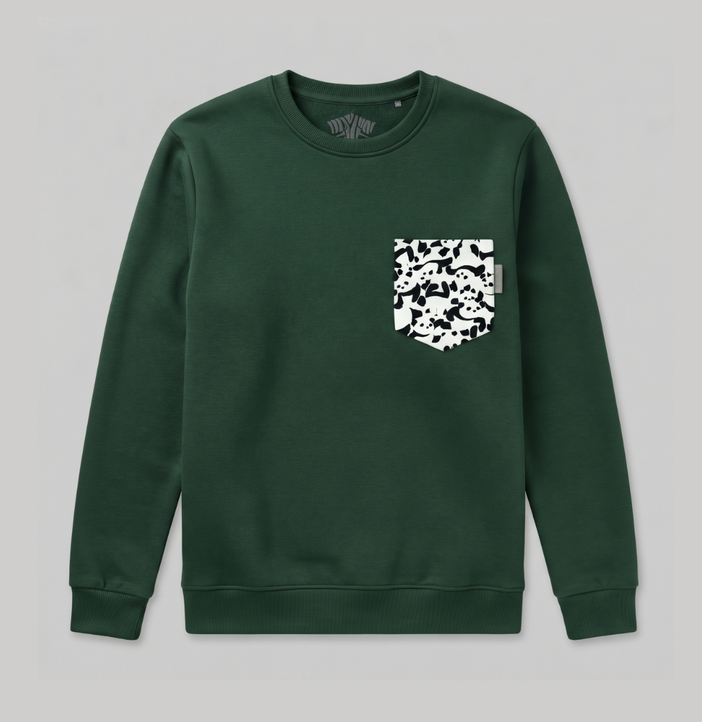 A dark green crewneck sweatshirt with a white and black camouflage patterned chest pocket, displayed flat against a neutral gray background.