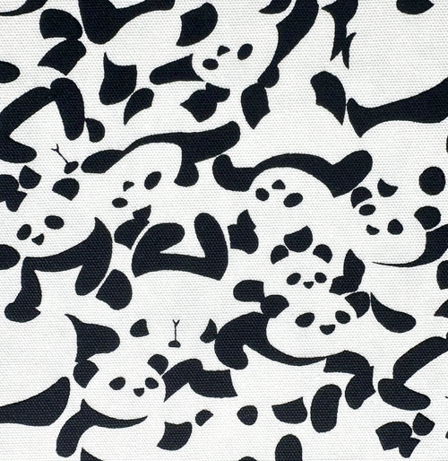A close-up of a fabric pattern featuring black abstract cartoon-like panda shapes on a white background.