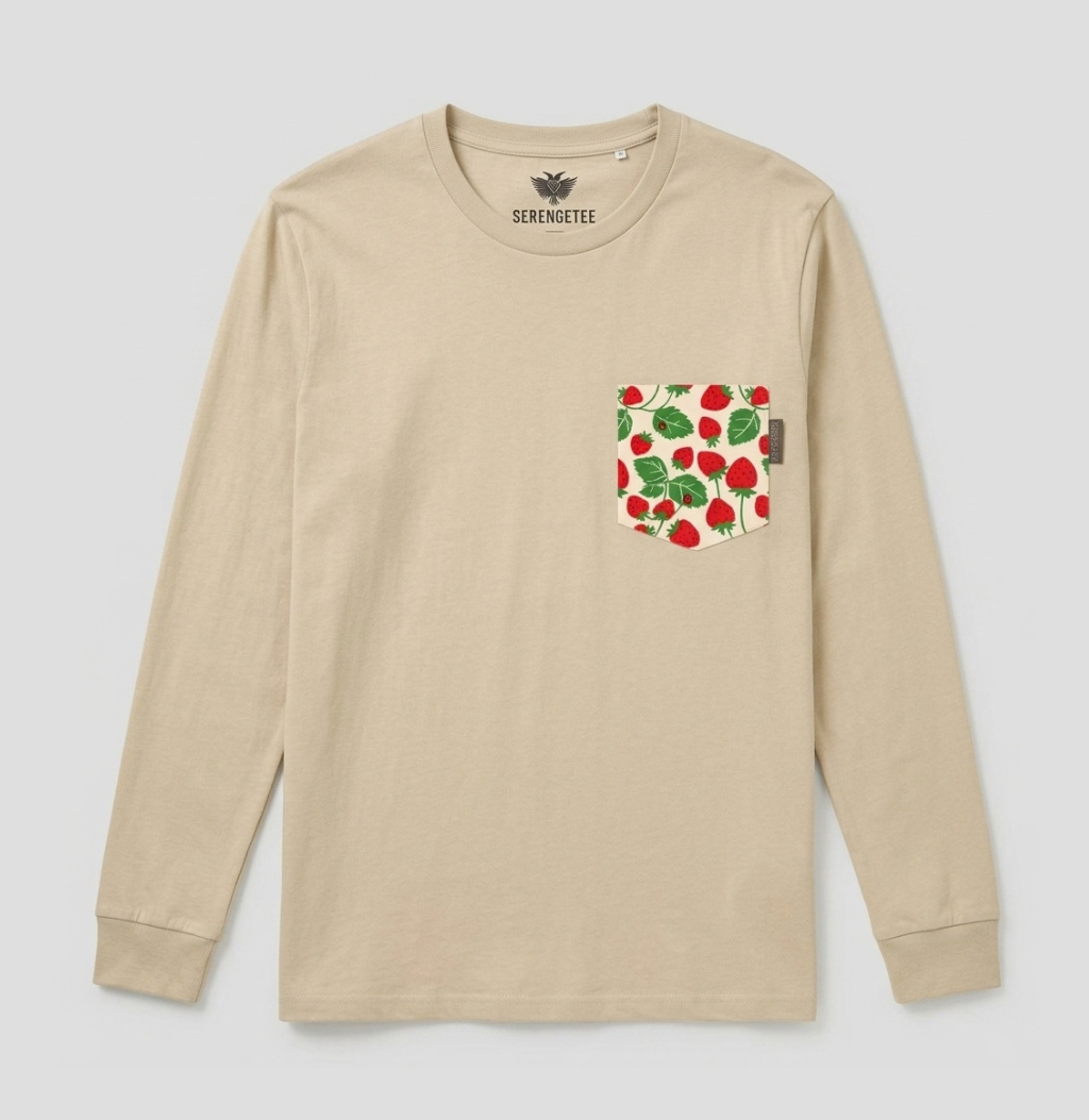 A beige long-sleeve crewneck shirt by Serengetee, featuring a chest pocket with a red strawberry and green leaf pattern, shown against a light gray background.
