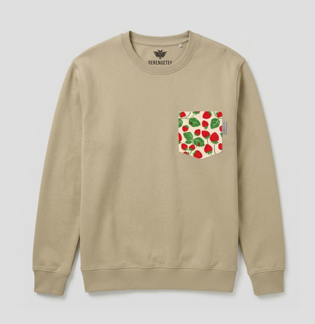 A beige crewneck sweatshirt with a chest pocket featuring a red strawberry and green leaf pattern, shown against a light gray background.