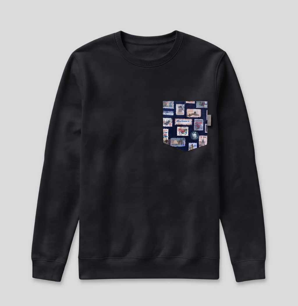 Navy passport stamp fabric pocket on a black crew sweatshirt.