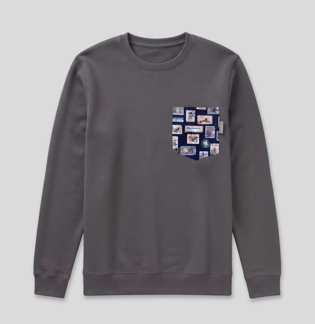 Navy passport stamp fabric pocket on a charcoal crew sweatshirt.