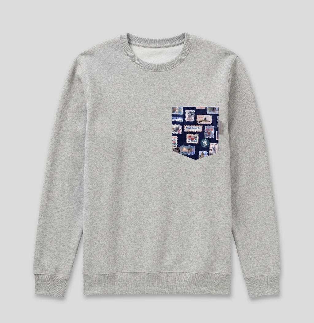 Navy passport stamp fabric pocket on a heather grey crew sweatshirt.