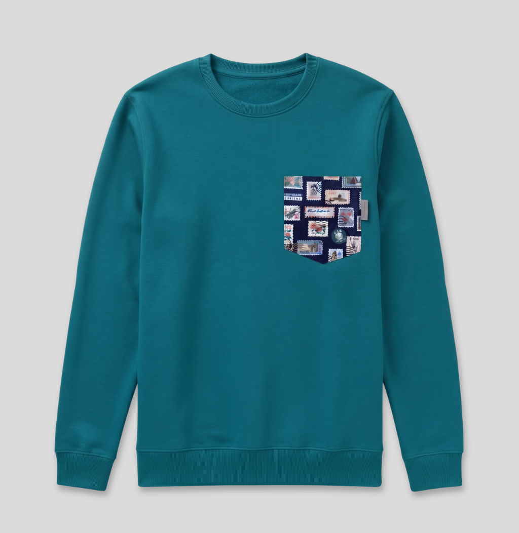 Navy passport stamp fabric pocket on a teal crew sweatshirt.